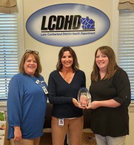 Sabrina Merrick accepts the October LCDHD Employee Excellence Award from Executive Director Amy Tomlinson and Laura Woodrum