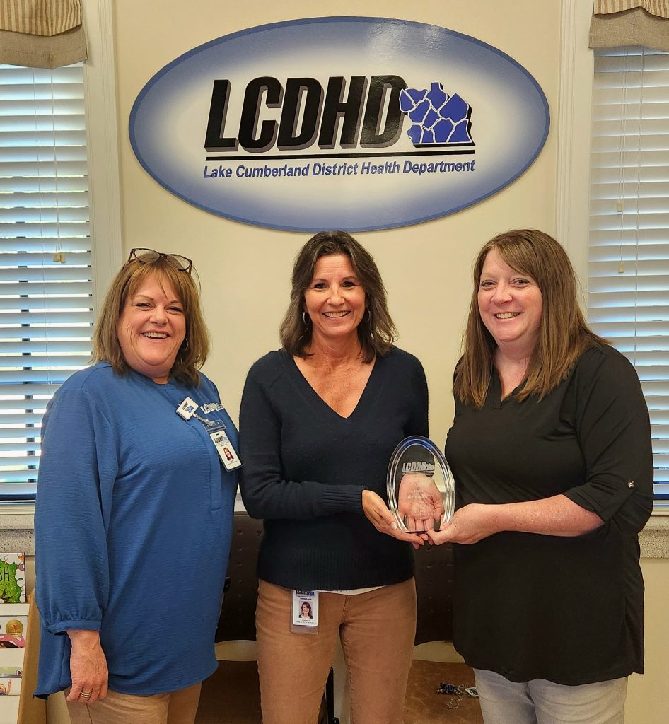 Sabrina Merrick accepts the October LCDHD Employee Excellence Award from Executive Director Amy Tomlinson and Laura Woodrum